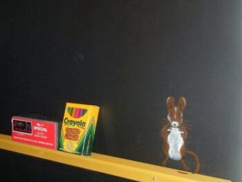 Stenciled mouse on blackboard wall